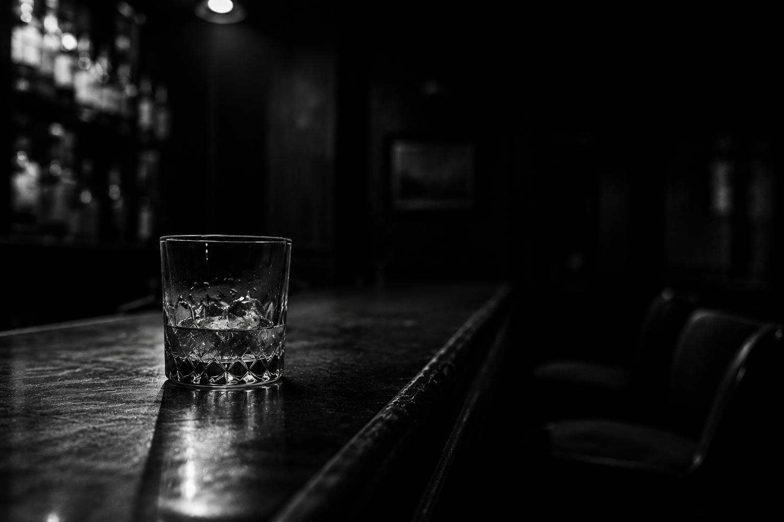 Abandoned glass of whiskey on a dark bar, the cost of drinkin