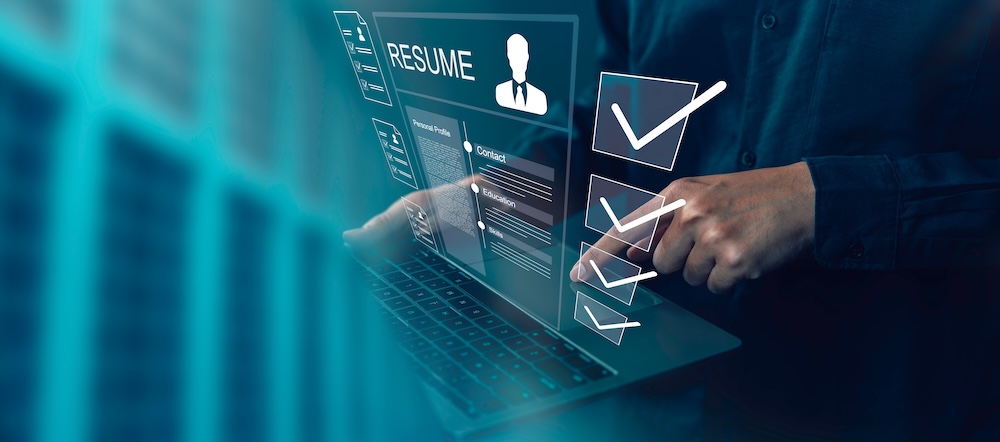 Person reviewing resumes on a laptop with digital checkmarks, illustrating HR support services and recruitment processes.
