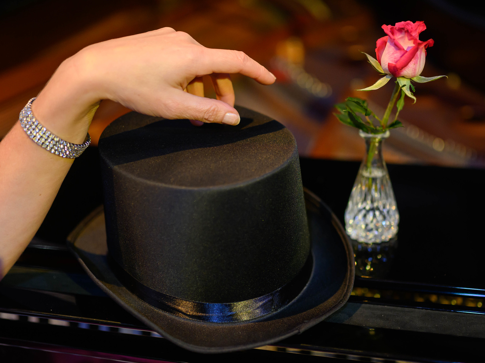 Gatsby-stemning med flosshatt og rose på et piano / A top hat and rose on a piano