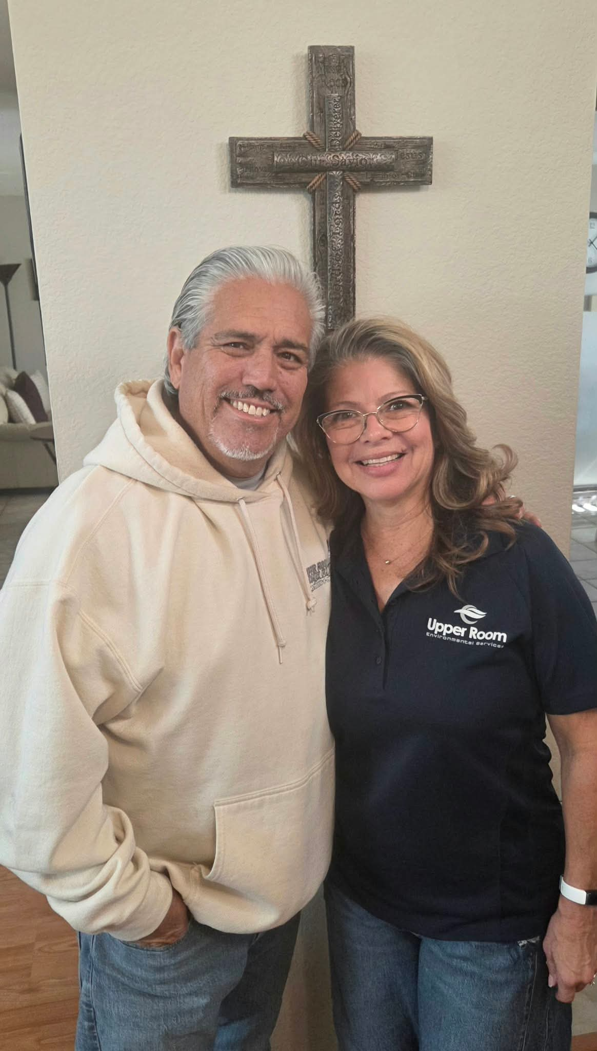 The husband-and-wife owners of Upper Room Custom Painting, standing together at home.