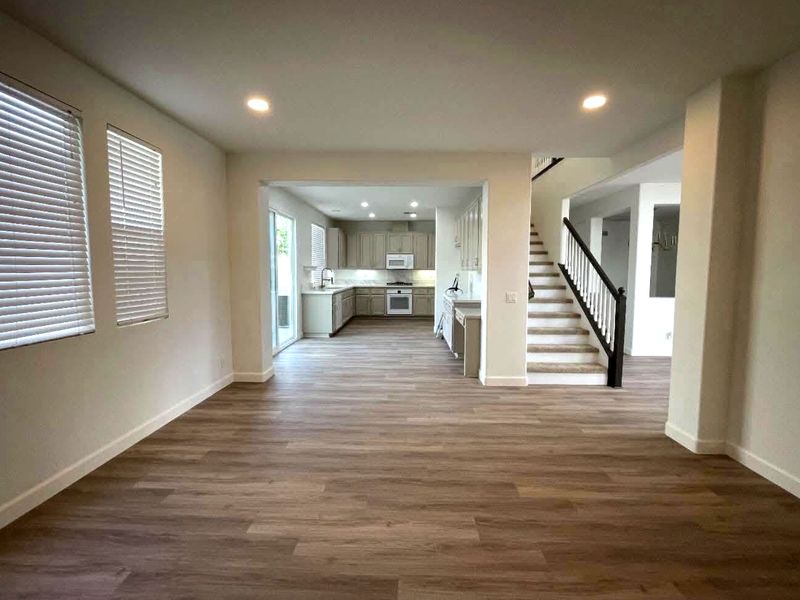 Freshly painted open-plan living room and kitchen with clean white walls and ceilings.