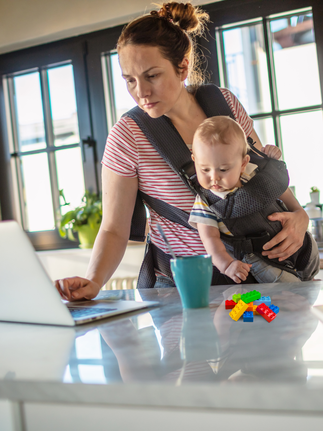 Mom working on a laptop with a kid