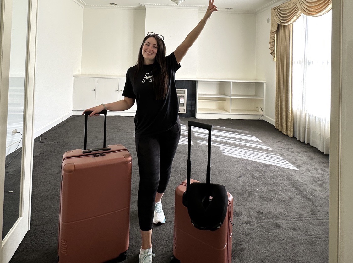 Alisha leaving the Melbourne apartment with two pink suitcases