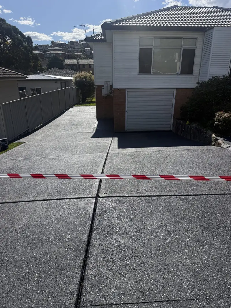 Exposed aggregate driveway after cleaning and charcoal colour sealing