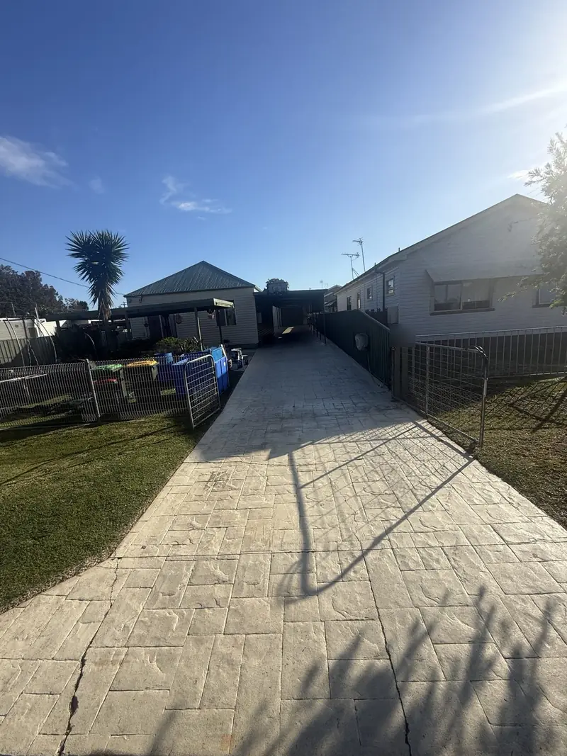 Faded stamped concrete driveway before colour sealing