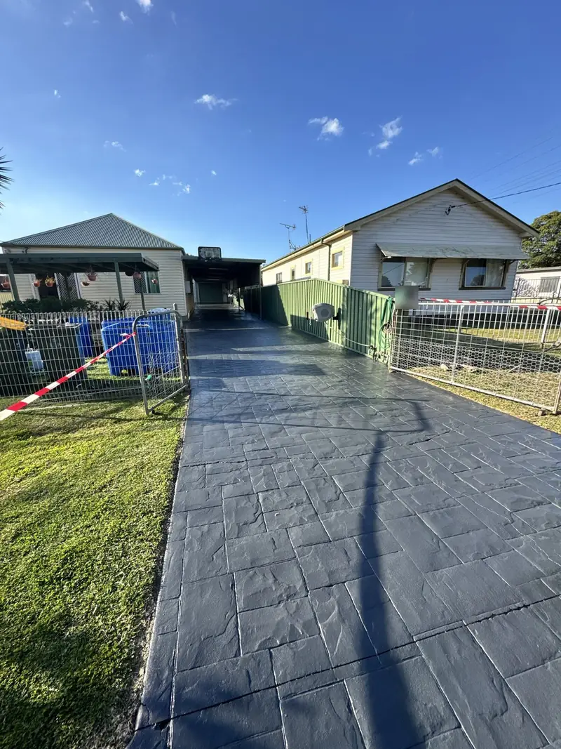 Stamped concrete driveway after dark grey colour sealing