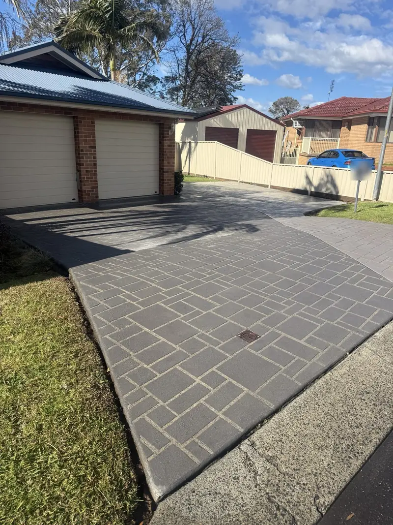 Faded stamped concrete driveway with pale grout lines before colour sealing
