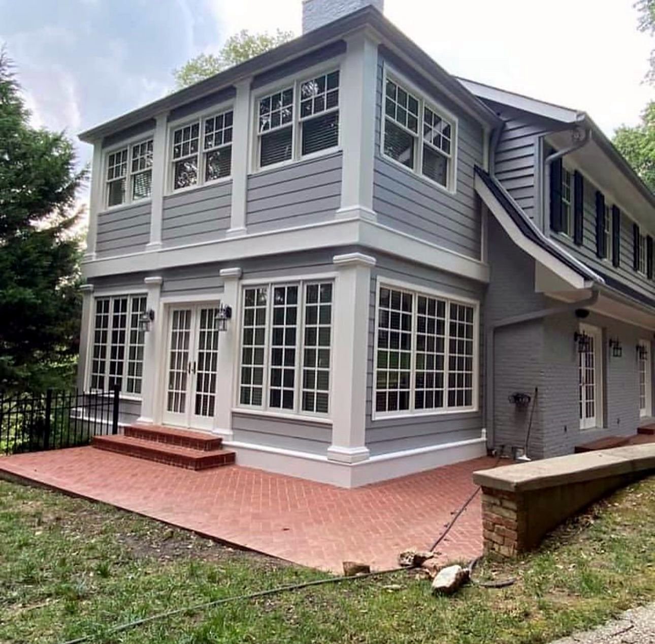 Two-storey weatherboard house freshly repainted in grey with crisp white trims