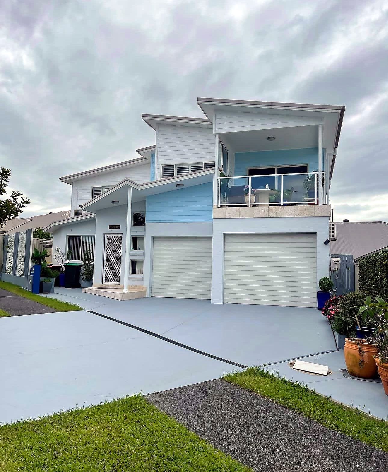 Modern two-storey home painted white with a soft blue feature