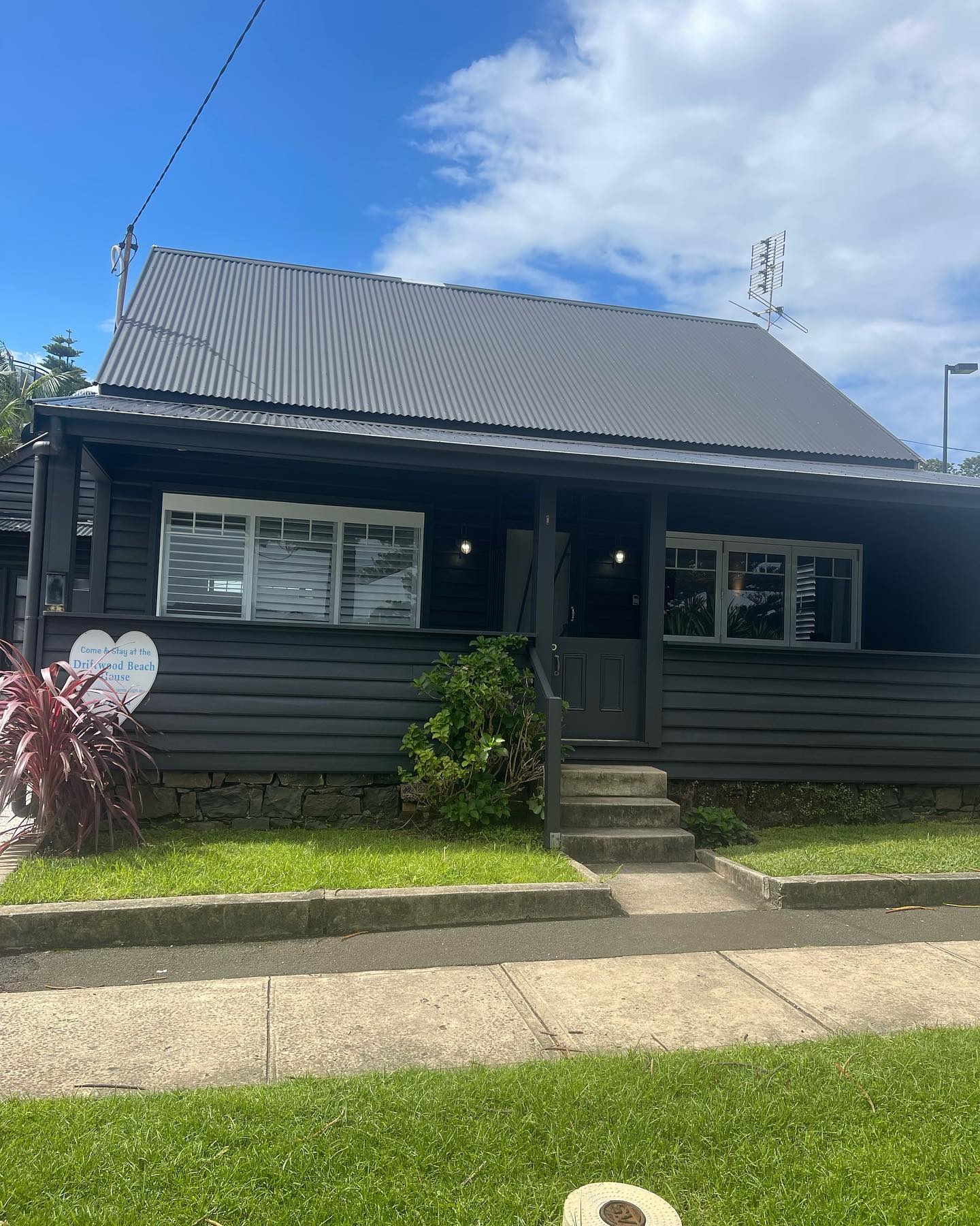 Weatherboard cottage painted charcoal