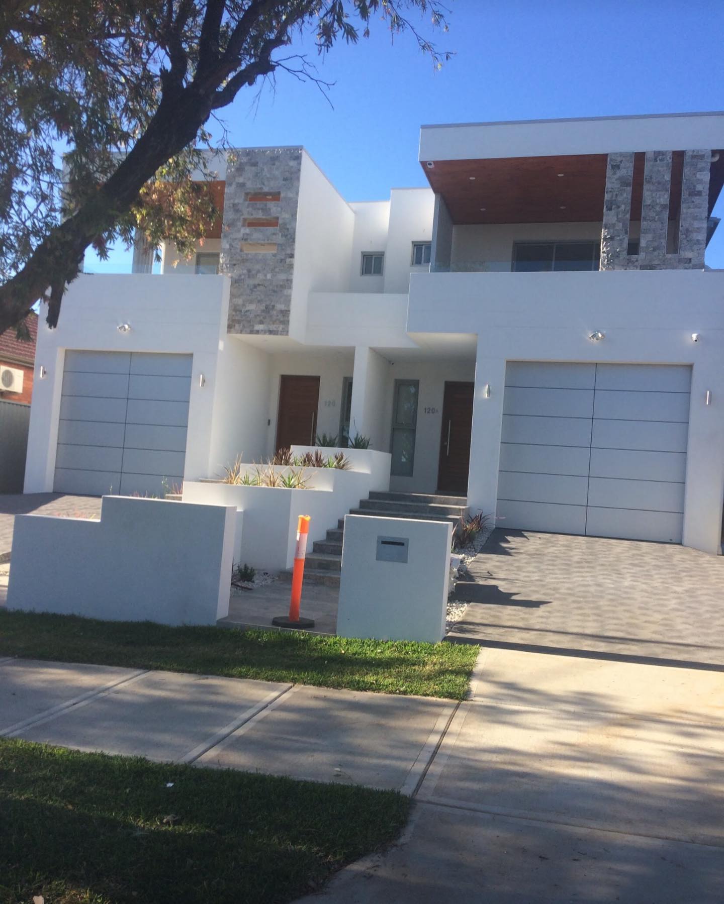 New duplex homes painted white with timber accents