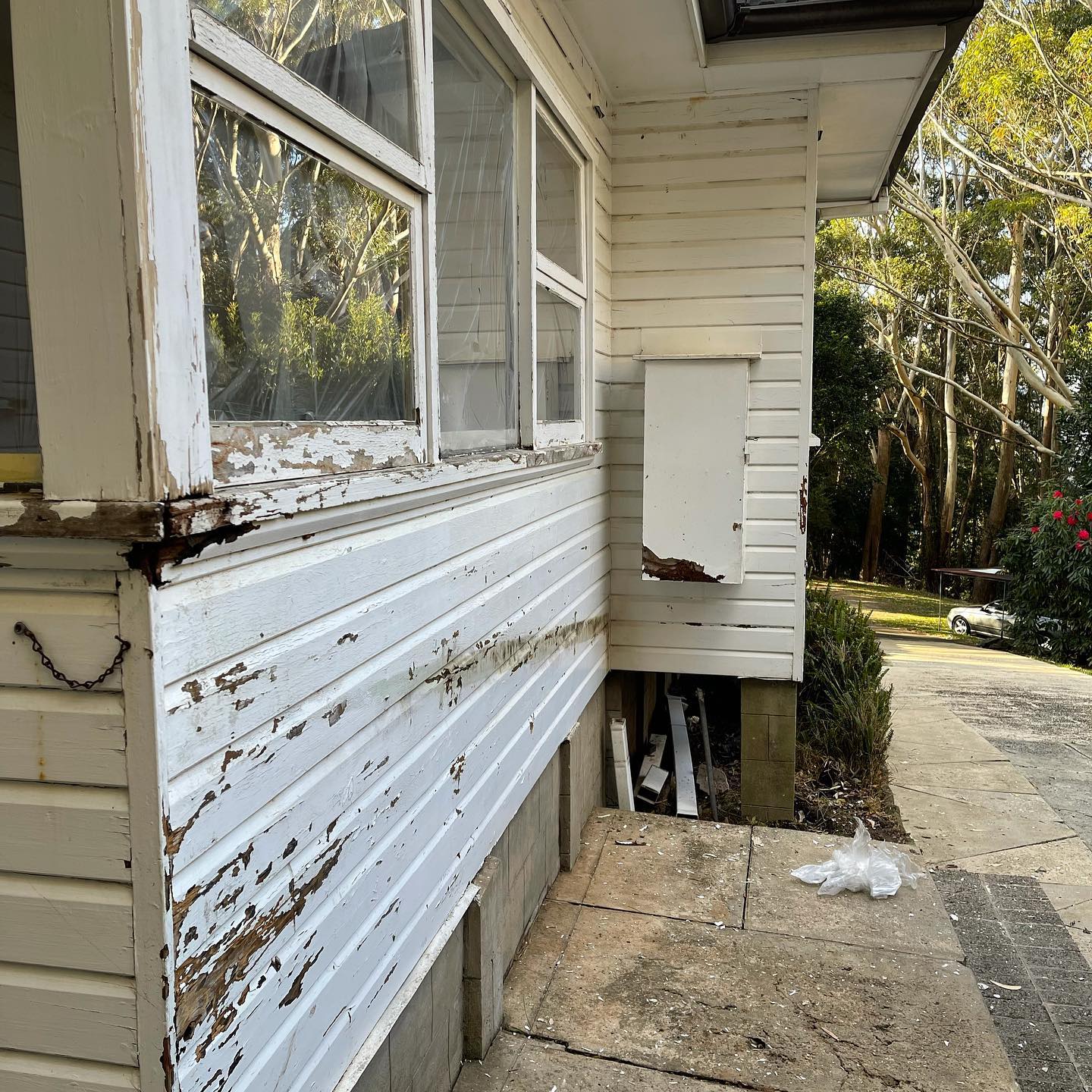 Weatherboards with cracked and peeling paint before repainting