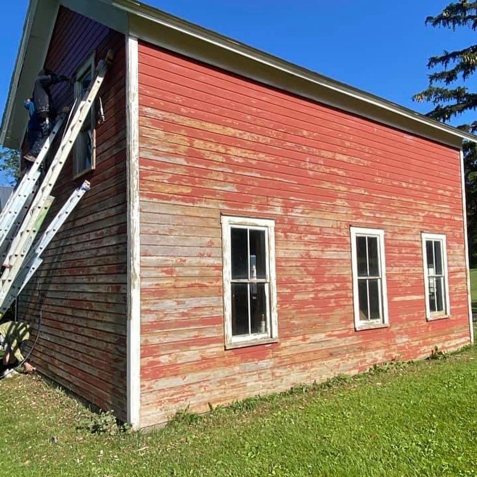 Faded red weatherboard wall before repainting