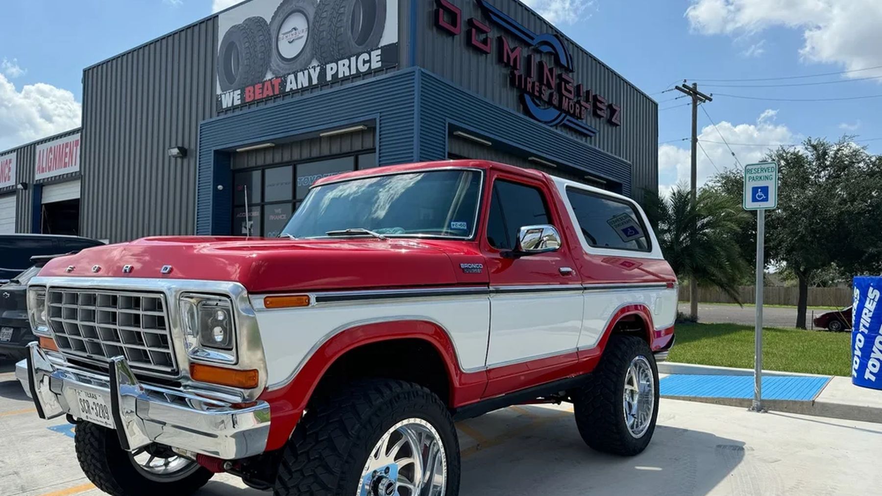 Ford Bronco with chrome wheels parked in front of the Dominguez Tires and More shop.