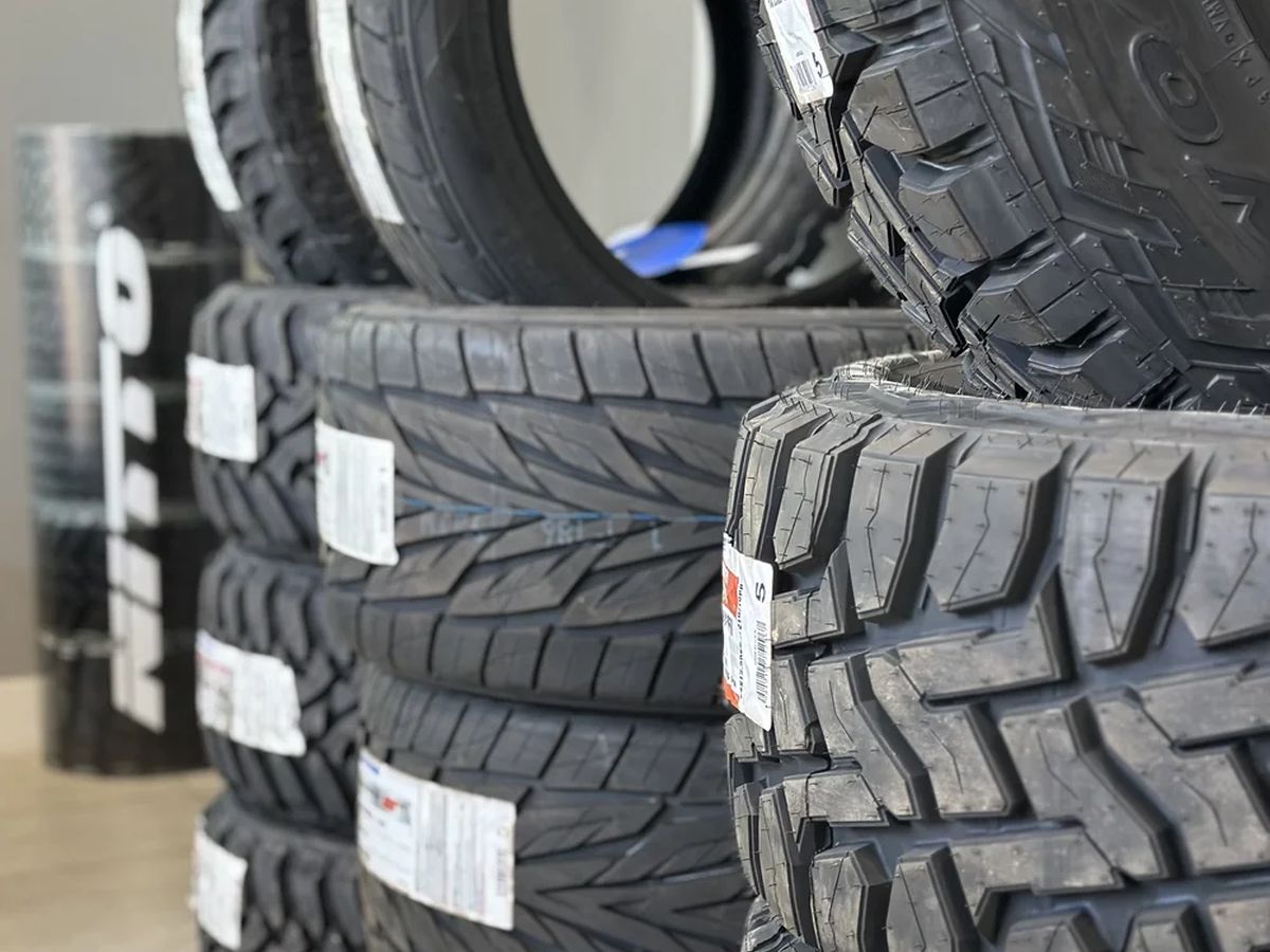 Stacked Nitto and Toyo tires with price tags.