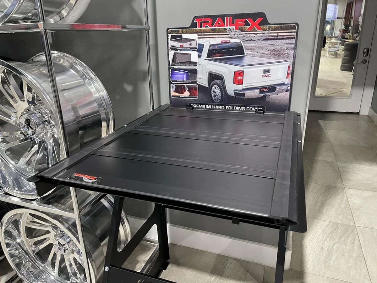 Folding bed cover on display next to chrome wheels.