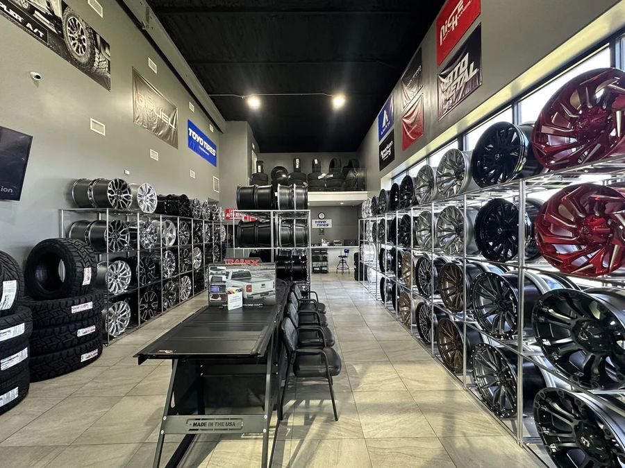 Full wall of wheels on display inside the shop, both sides.