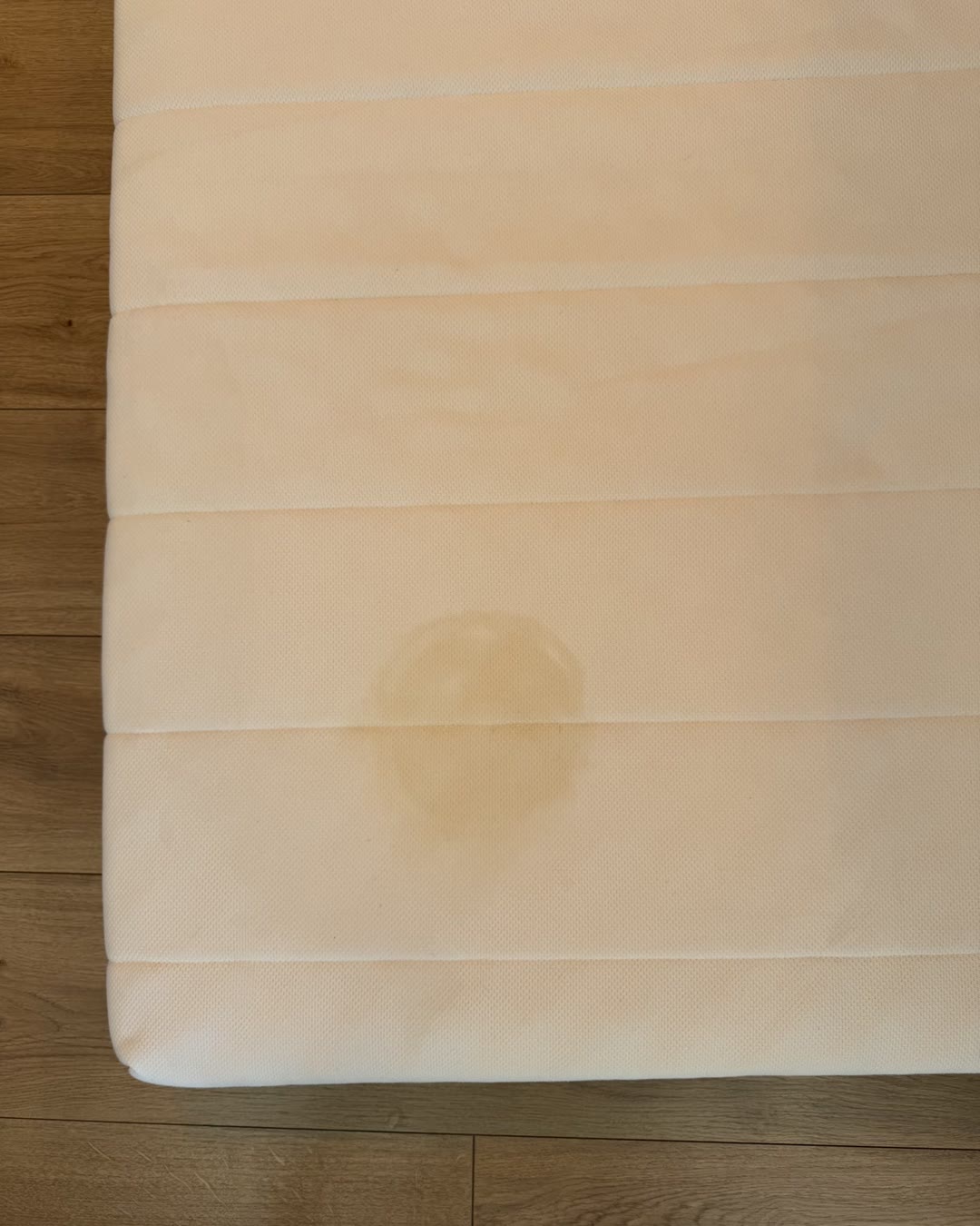 Nettoyage matelas Toulouse : auréole de pipi d’enfant sur un matelas en mousse, avant nettoyage