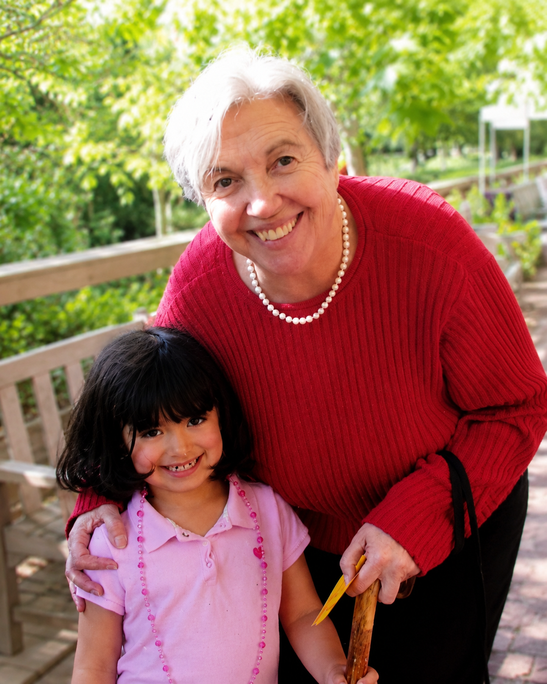 Zoe as a young girl smiling with her grandma outdoors