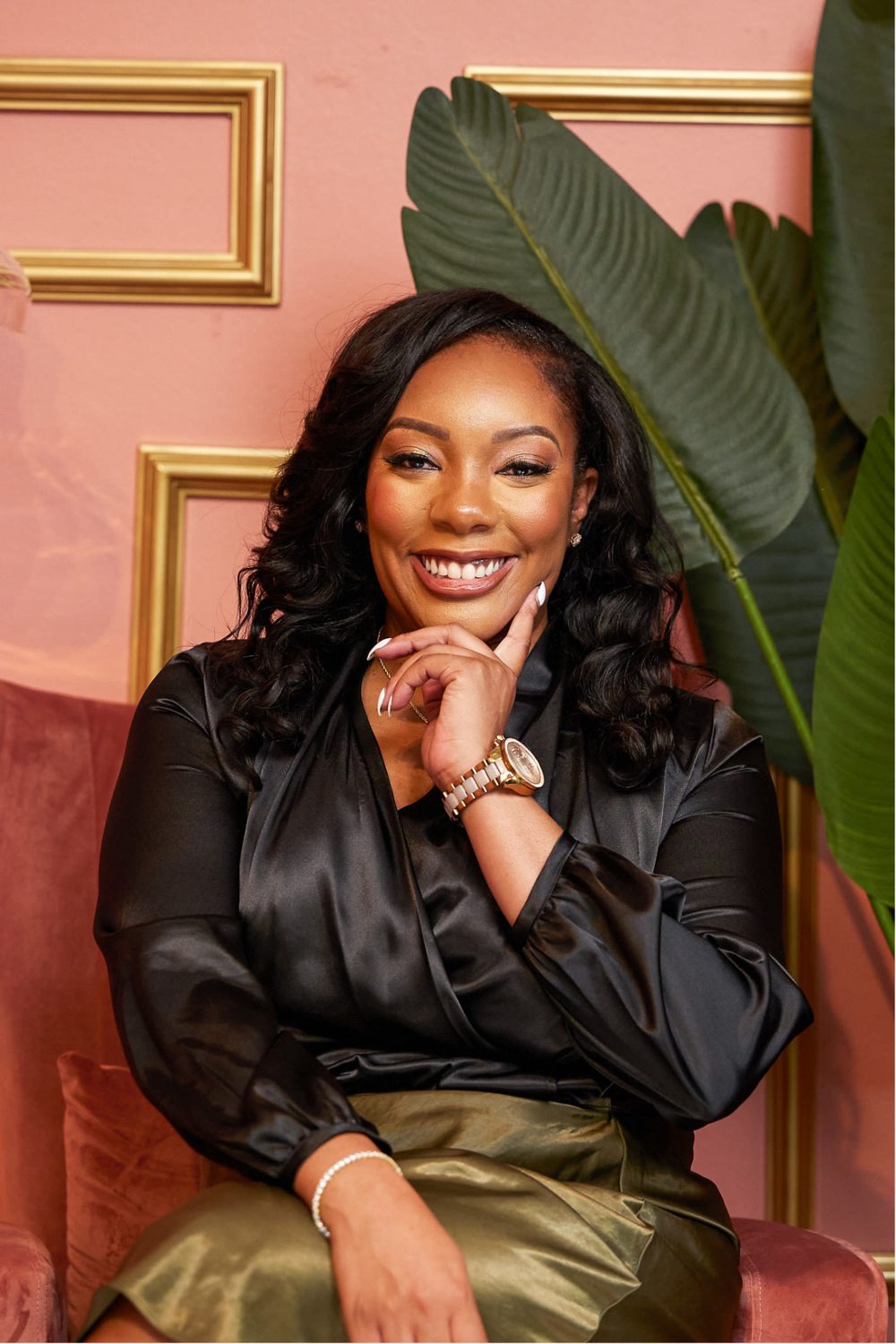 Dr. Eukeethia B. smiling in front of gold frames