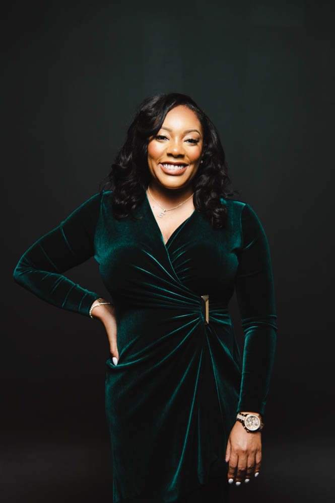 Dr. Eukeethia Barnes, business strategist and speaker, in a rich green velvet dress
