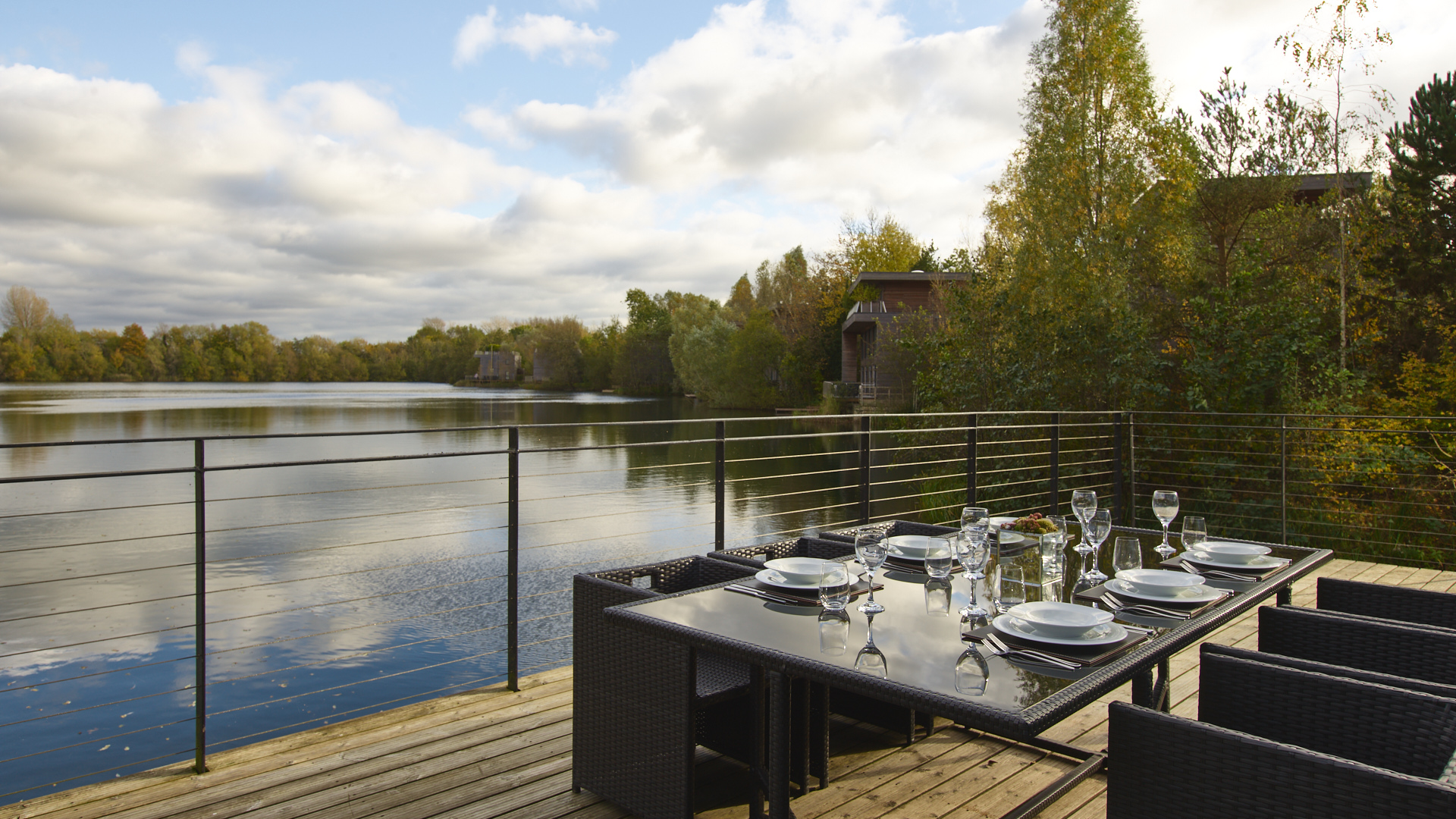 The Glass House viewed from the lakeside, showing the Shou Sugi Ban timber cladding and floor-to-ceiling triple-glazed walls
