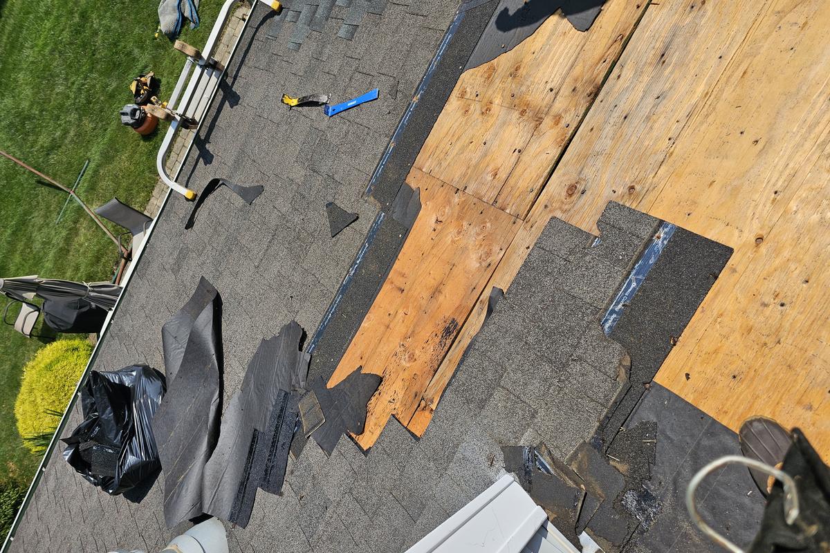 Damaged shingles stripped back to bare roof decking on a repair in East Berlin, Connecticut