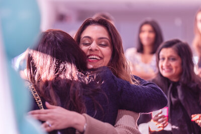 Two women embracing at SHINE & RISE London 2026, reflecting connection, support, and empowered women building community together.