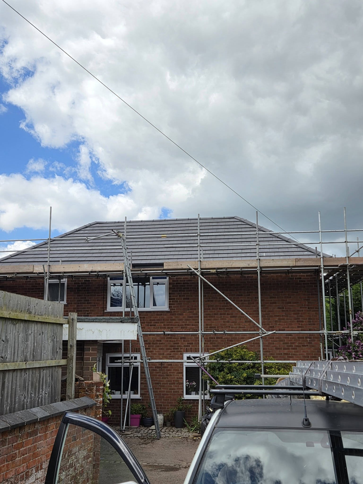 Completed grey tiled hip roof on a house in Cheshire