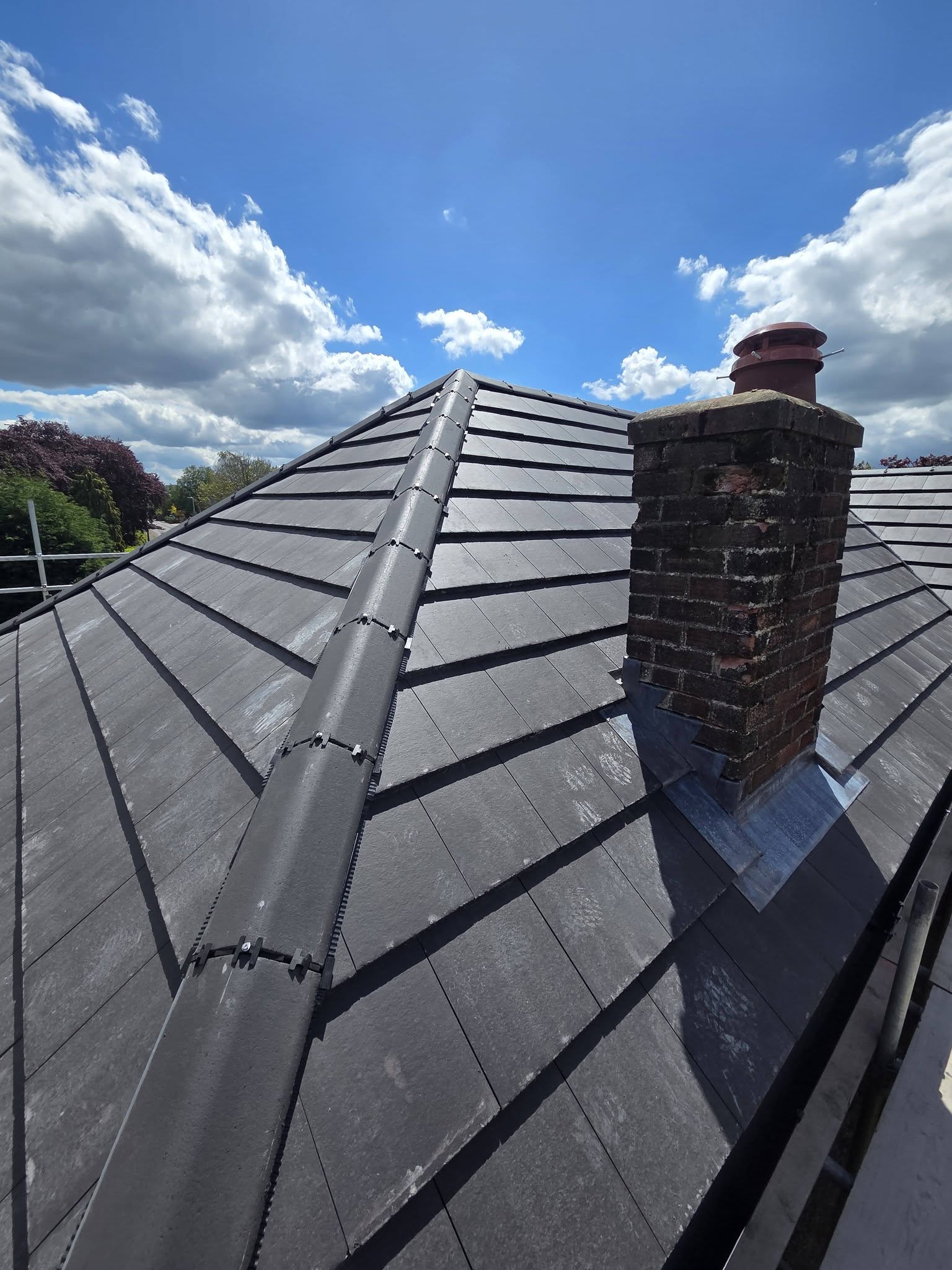 Finished grey tiled roof with brick chimney and new lead flashing