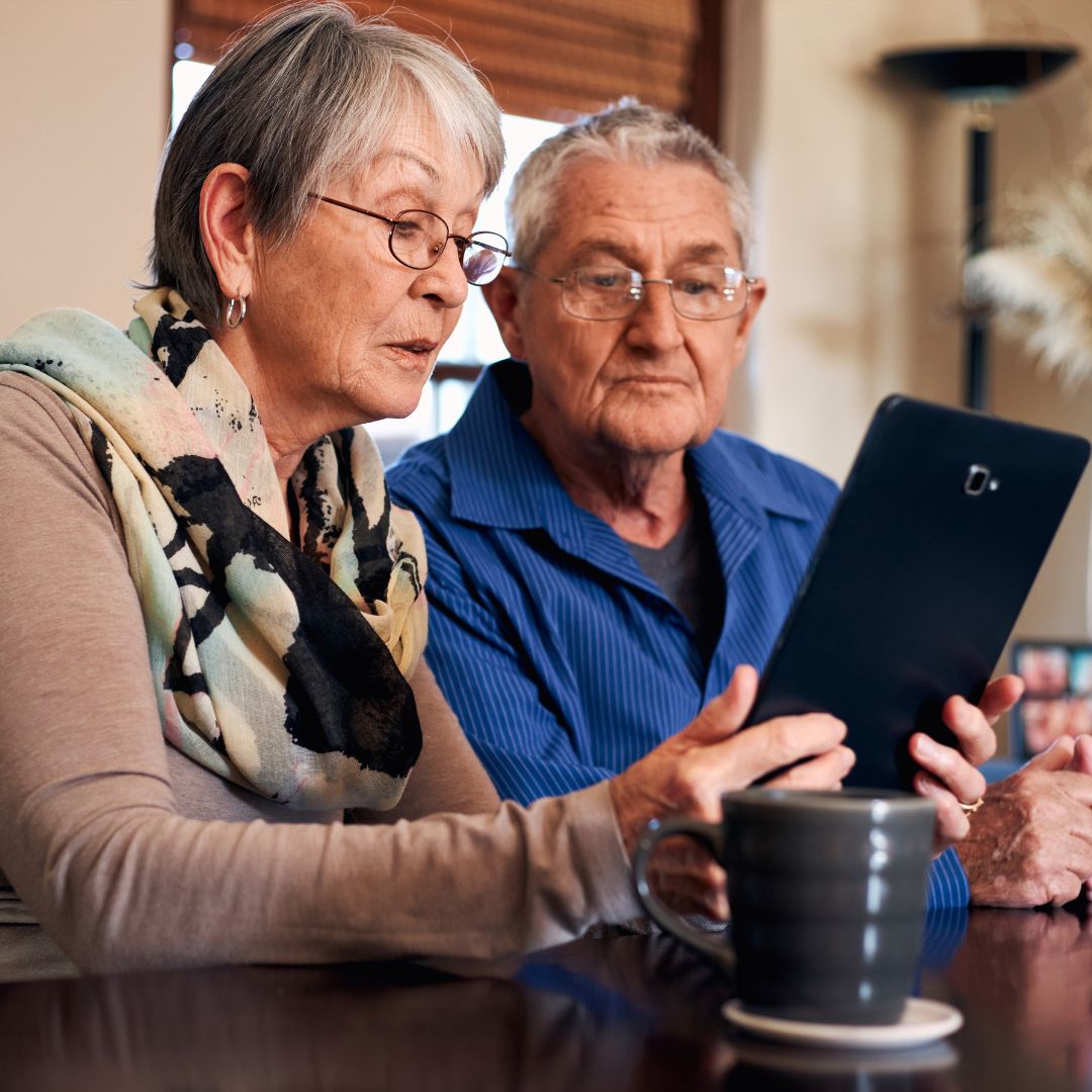 Two Seniors Looking At A Tablet