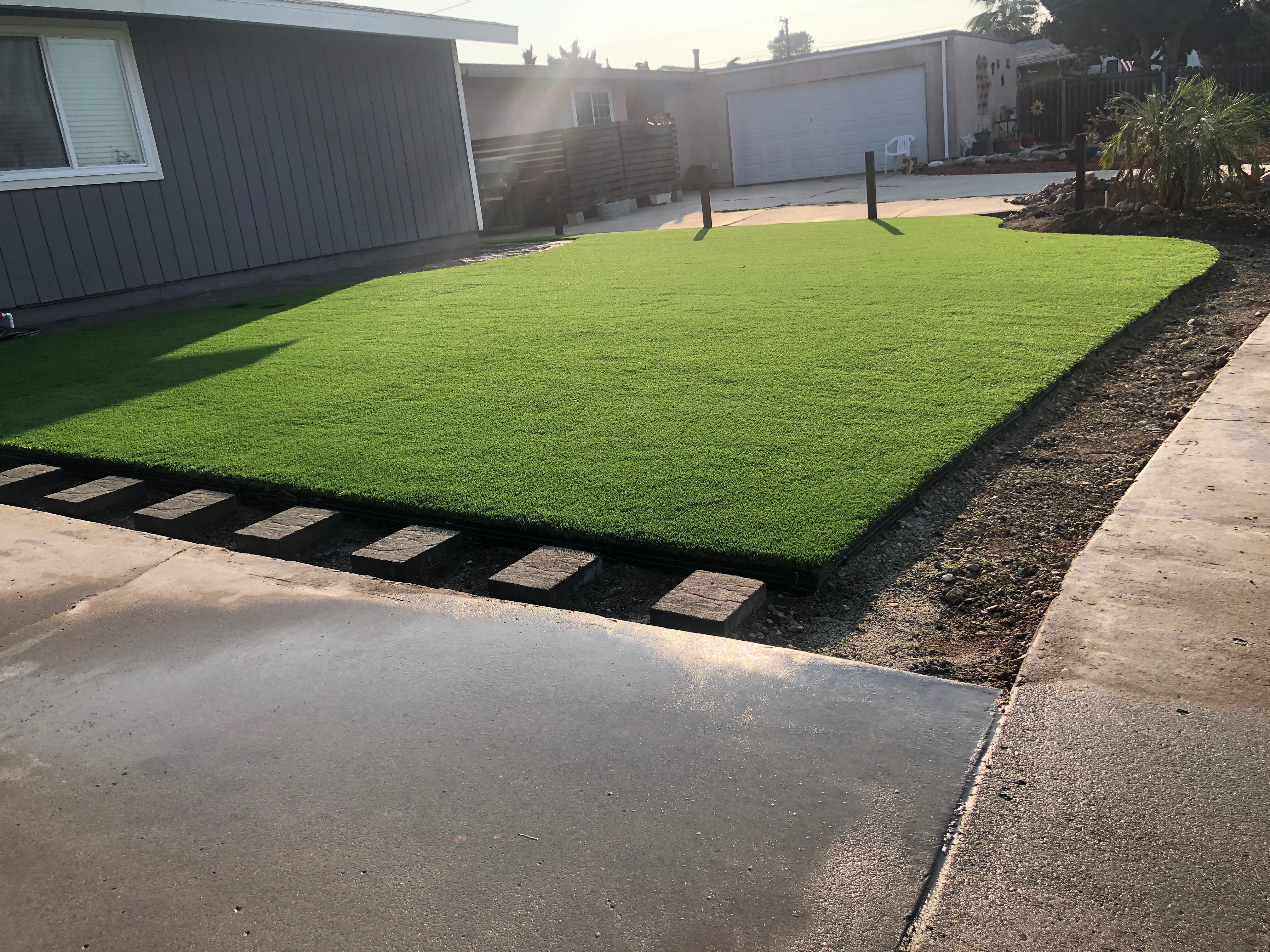 Front yard residential artificial turf installation with clean borders