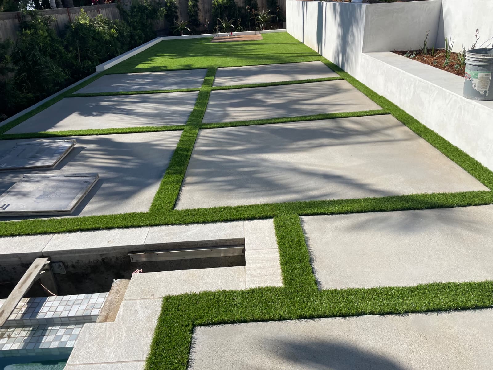 Artificial turf bands integrated between large concrete pavers