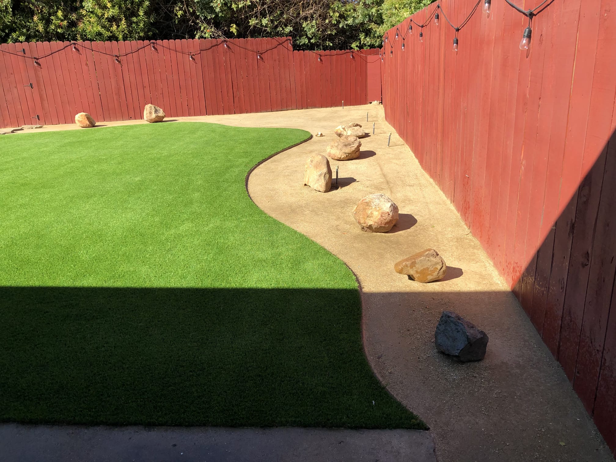 Compact turf design with curved border and boulders