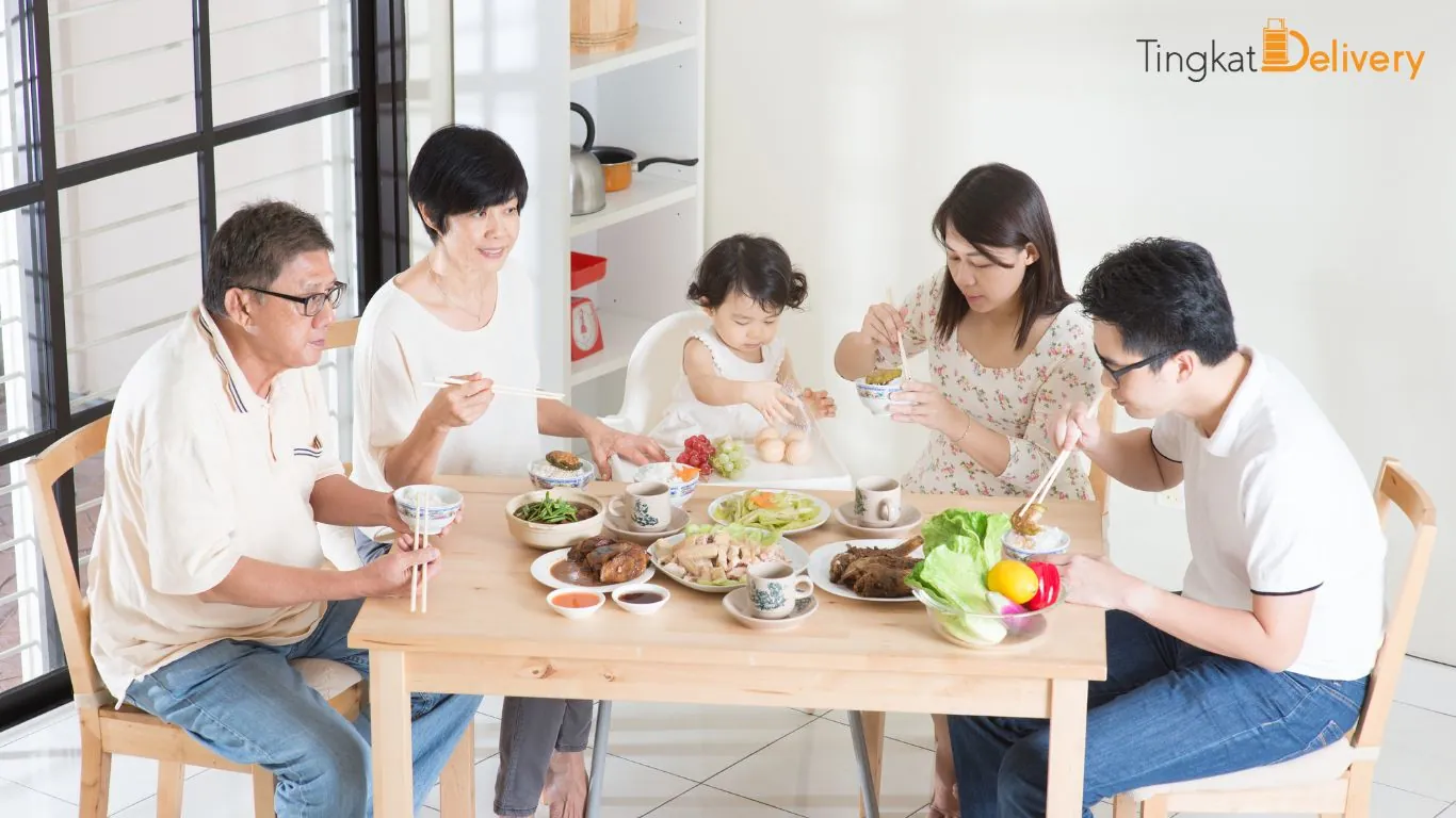 A family enjoying a home-cooked Tingkat Delivery meal together