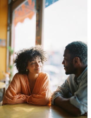 Couple sharing a warm conversation across a table, symbolising improved communication and emotional reconnection through marriage counselling. Couple sharing a warm conversation across a table, symbolising improved communication and emotional reconnection through marriage counselling.