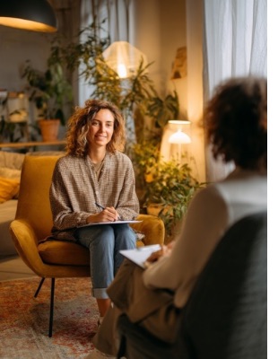Woman in an anger counselling session speaking with a counsellor, representing supportive help for irritability, reactivity, and emotional regulation. Woman in an anger counselling session speaking with a counsellor, representing supportive help for irritability, reactivity, and emotional regulation.