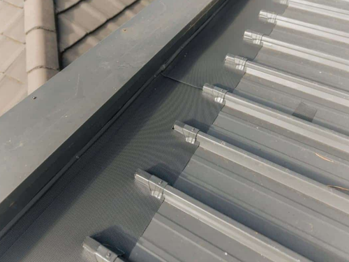Trimdek gutter guard — grey suburban roof