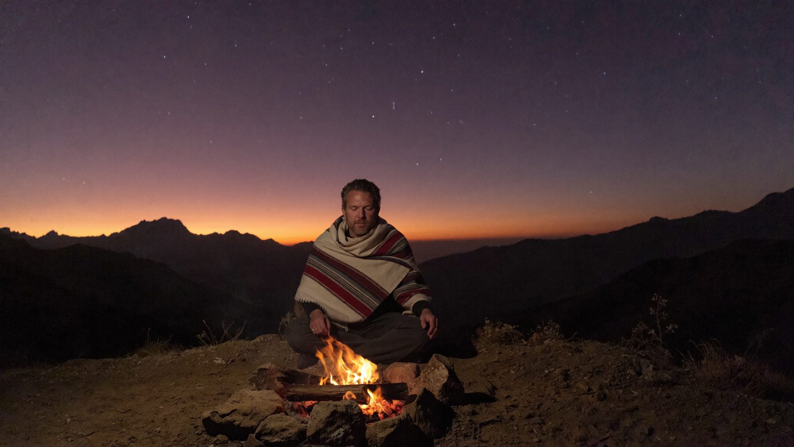 Eric reflecting by a fire in the Andes