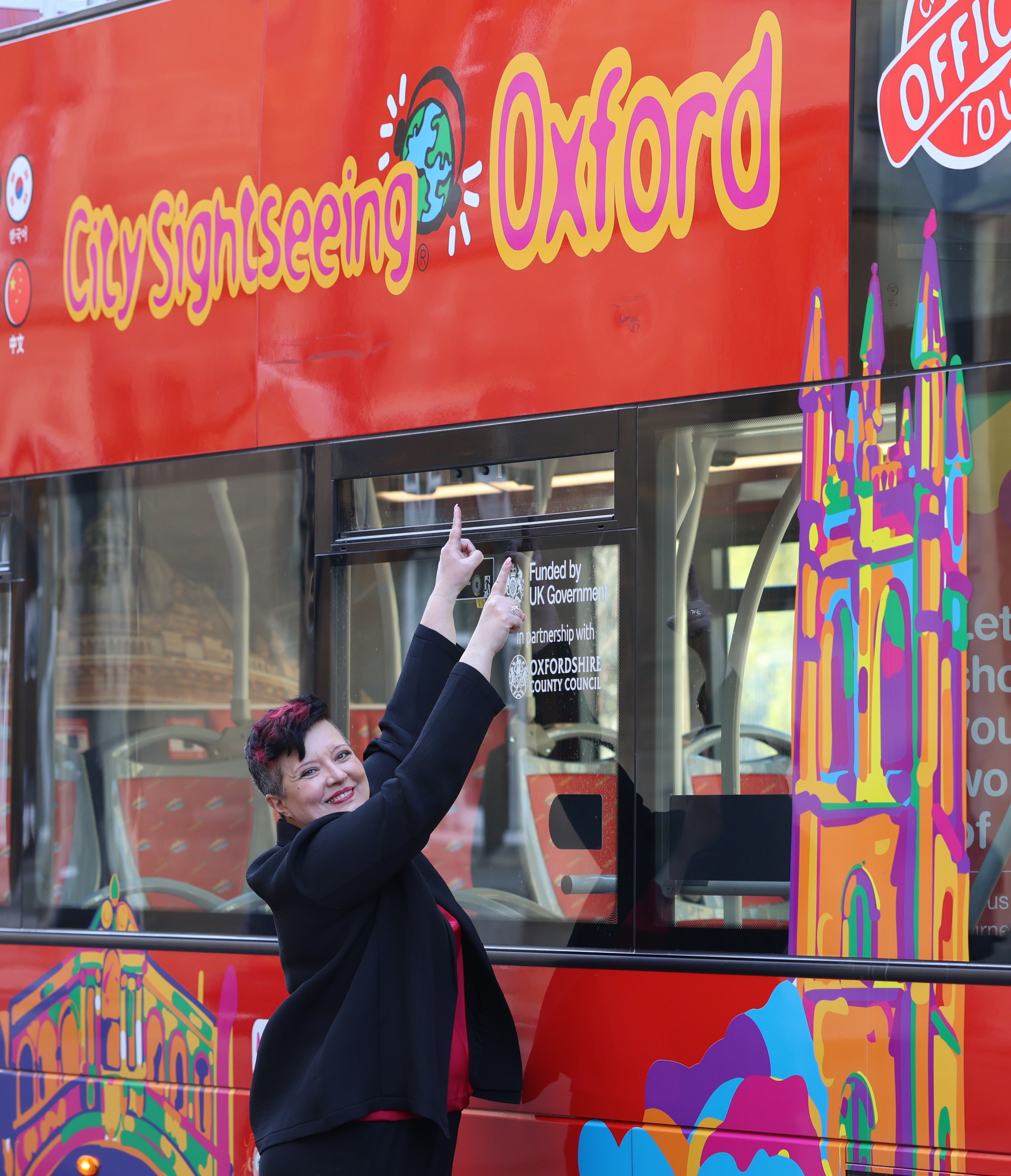 Vanessa Cardenas standing beside an Oxford sightseeing bus during her Oxford Talks appearance