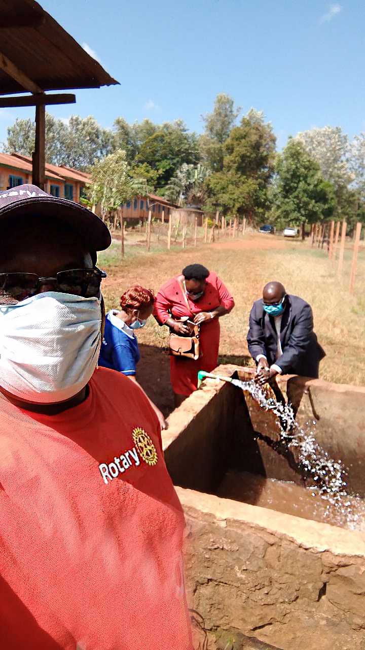 A Rotary member in the foreground watches as community leaders inaugurate a clean water well in rural Kenya