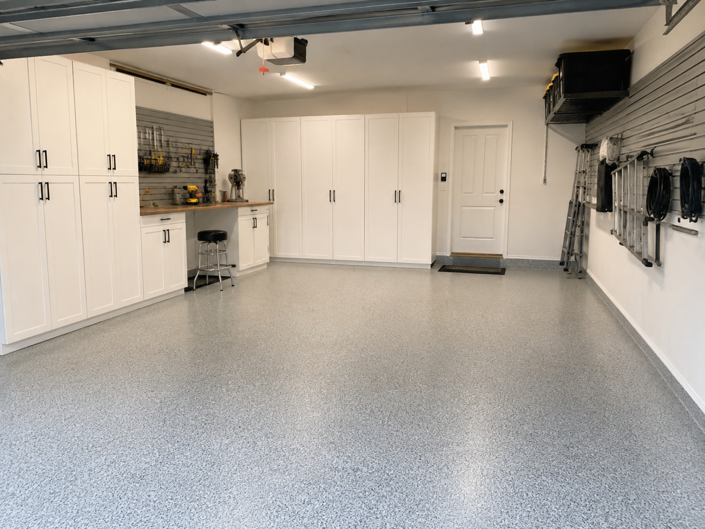 Organized garage with epoxy flooring and storage cabinets