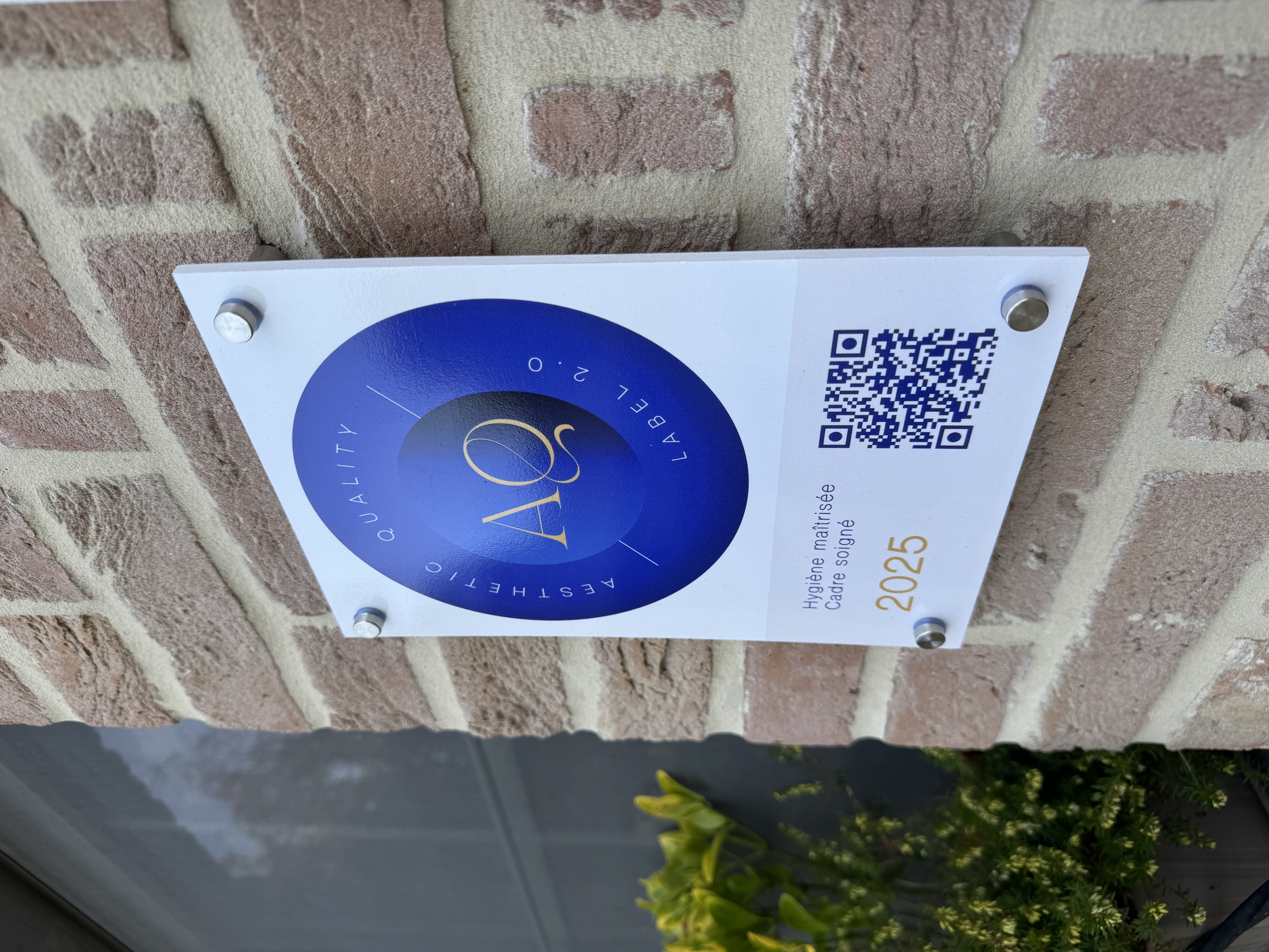 Plaquette Aesthetic Quality installée sur le mur d'un institut labellisé
