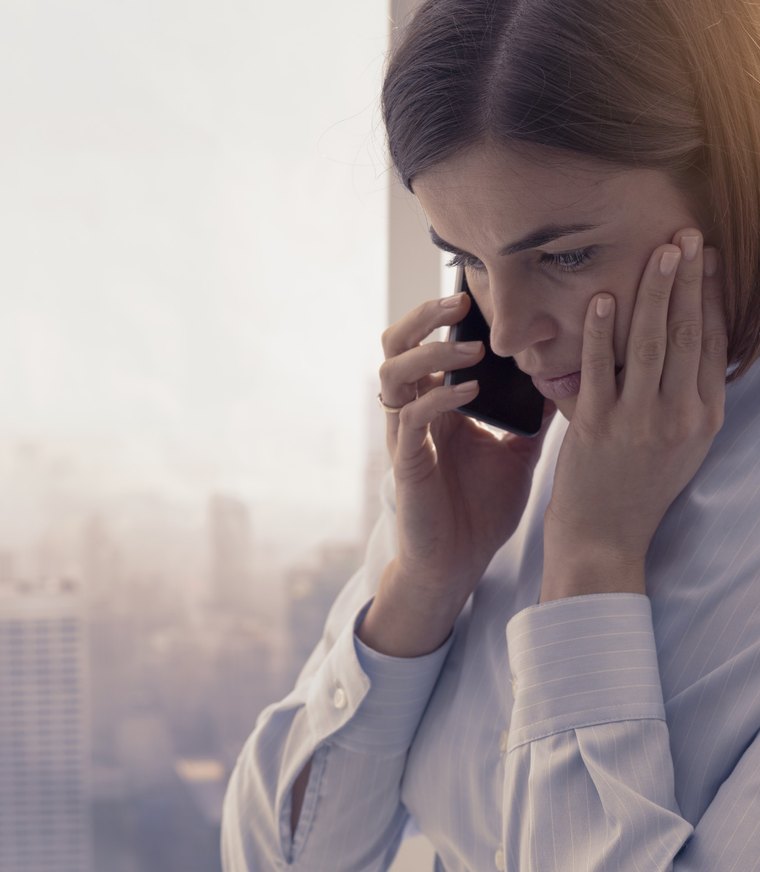 A business owner on the phone, looking overwhelmed