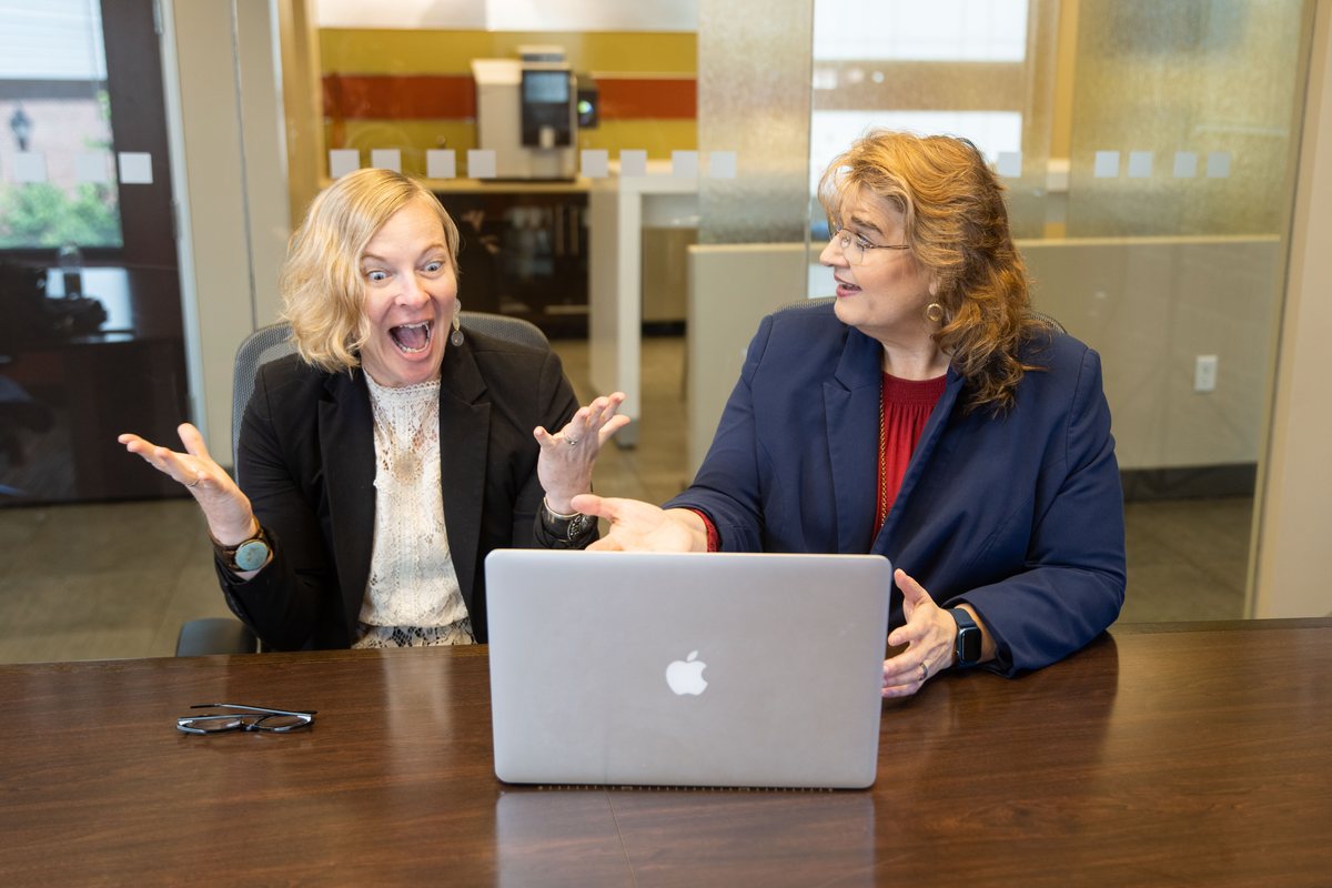 Laura working through a plan with a client at a laptop