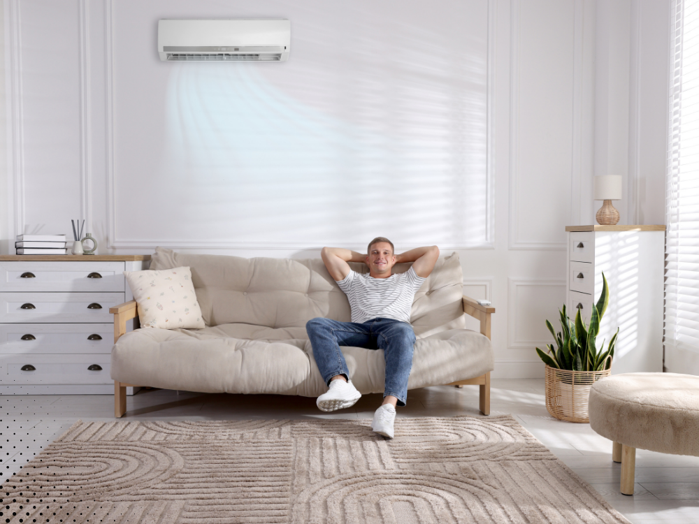 Man relaxing indoors with HVAC running during indoor air quality testing in a Delaware home.