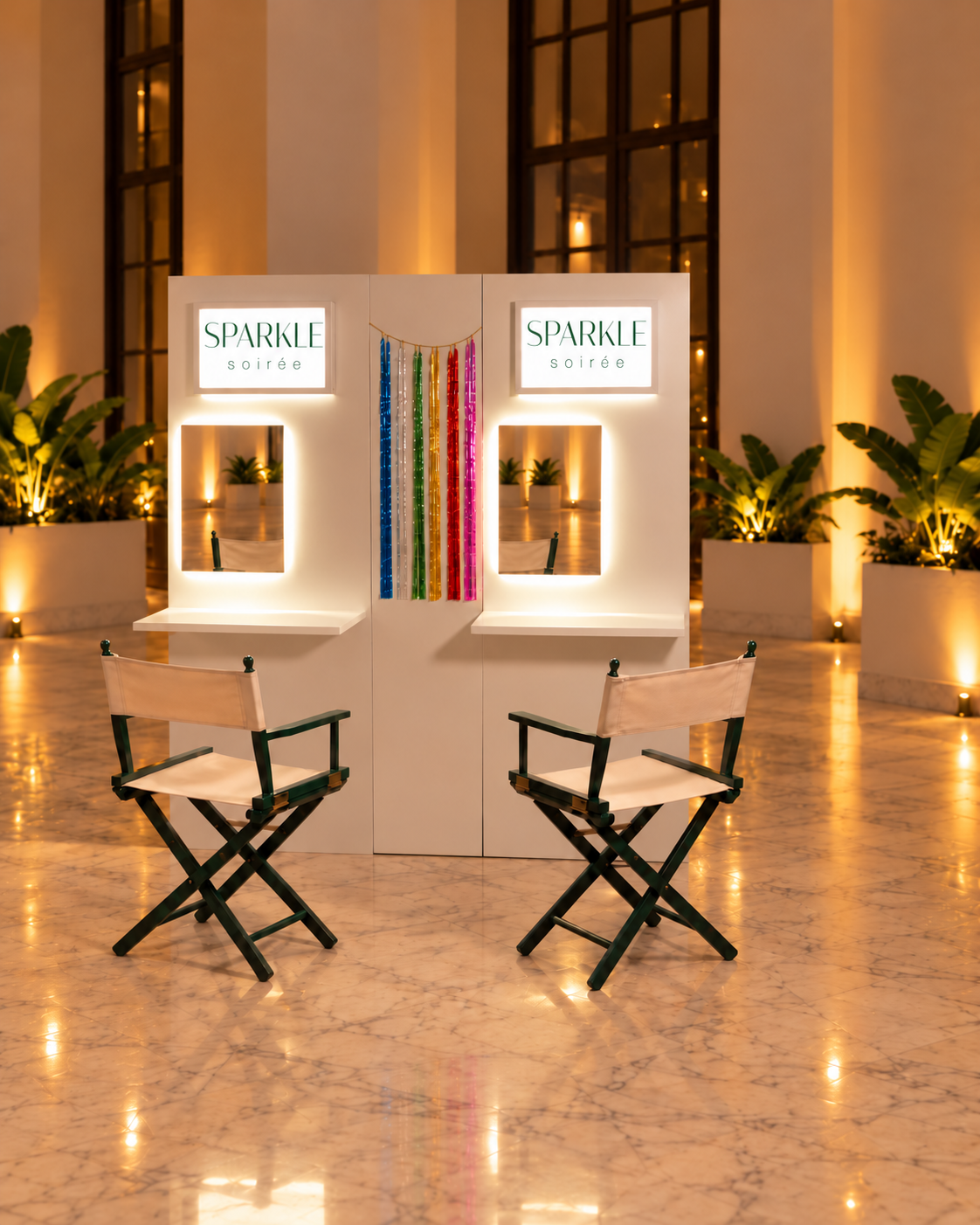 Le Sparkle Bar : deux postes avec miroirs lumineux, les sparkles au centre et deux chaises vertes, dans une salle de réception.