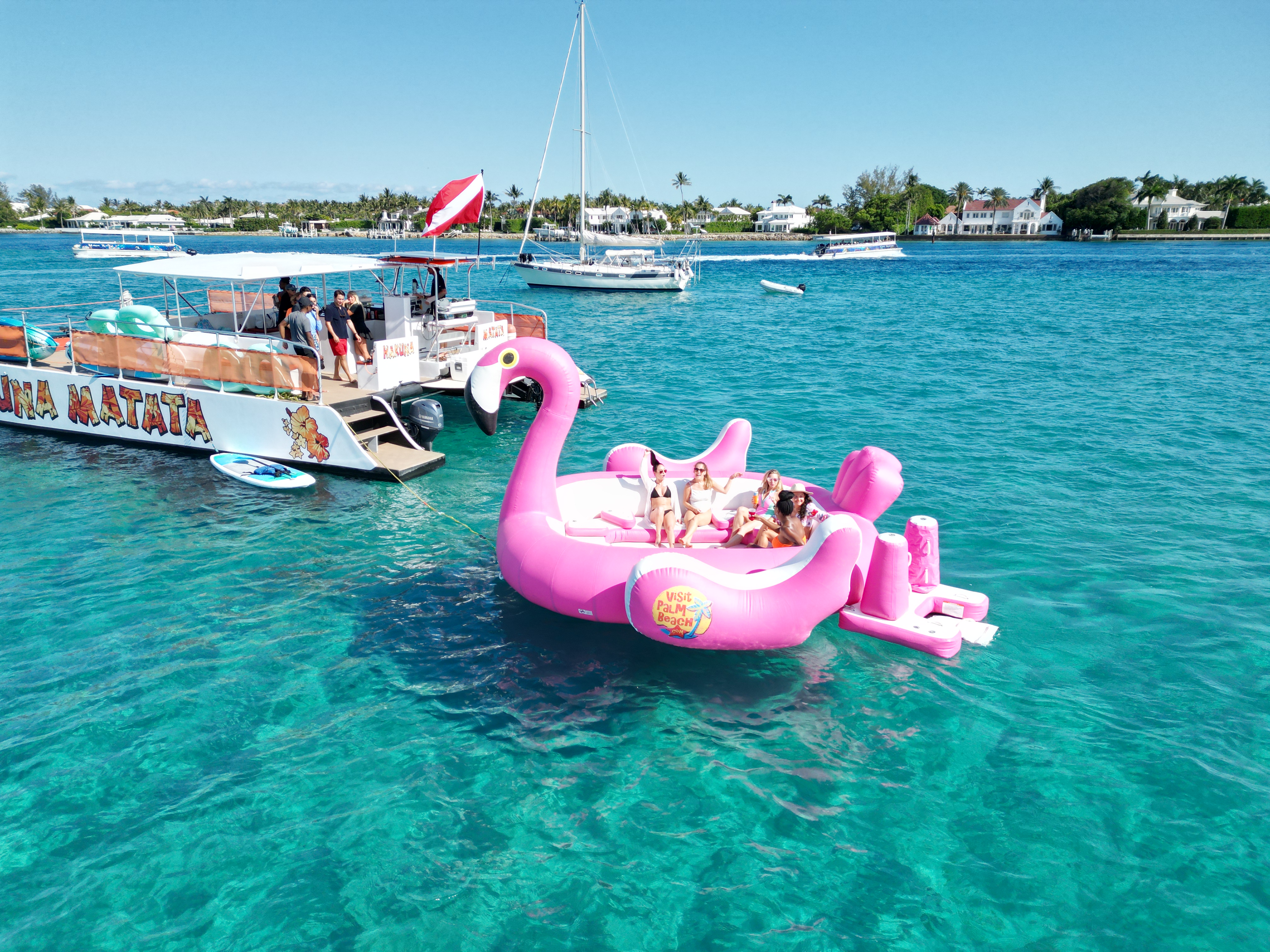 Giant flamingo float in crystal clear water with the Hakuna Matata