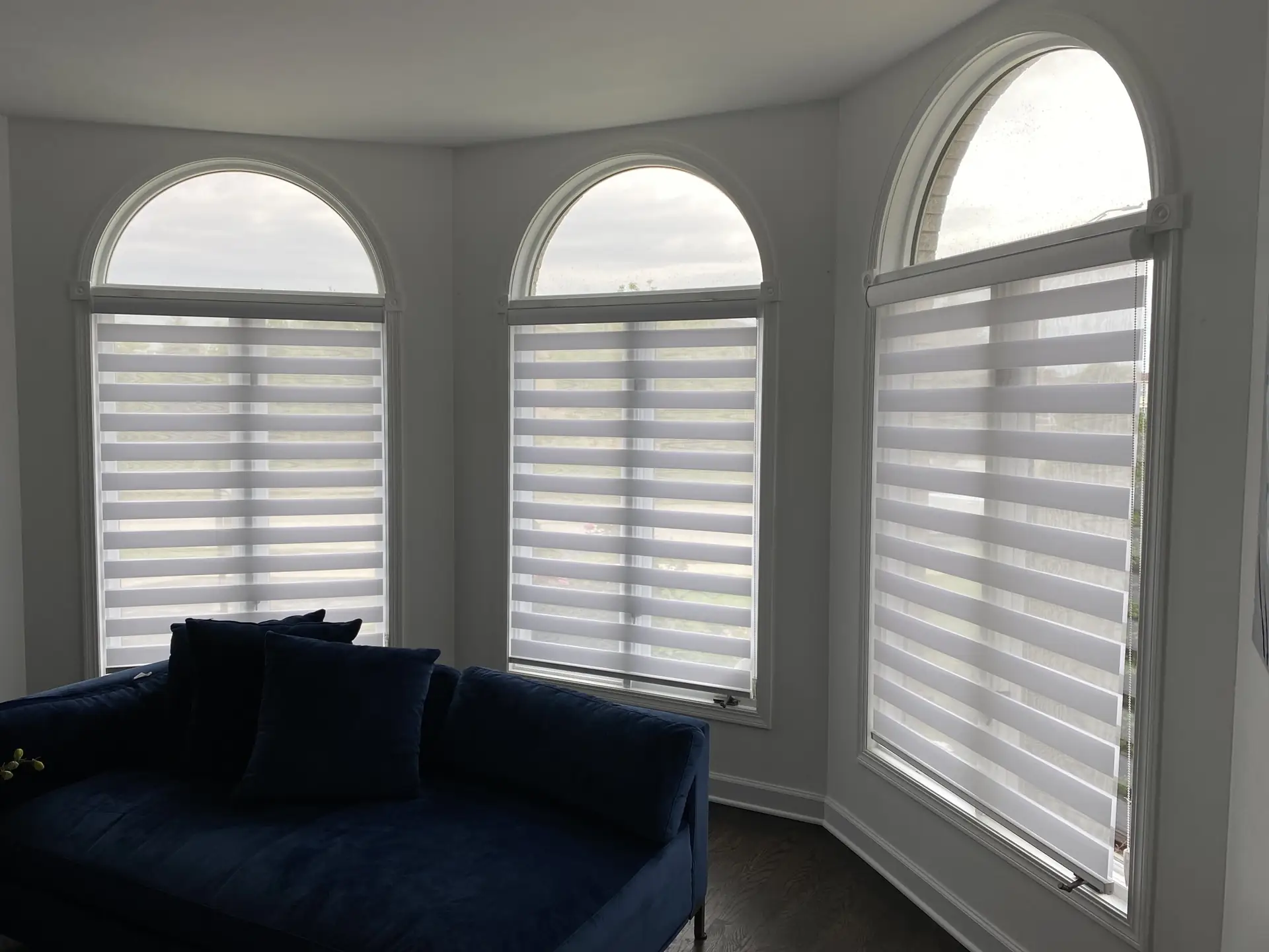 Custom shades in a tall arched bay window in a Chicago-area home
