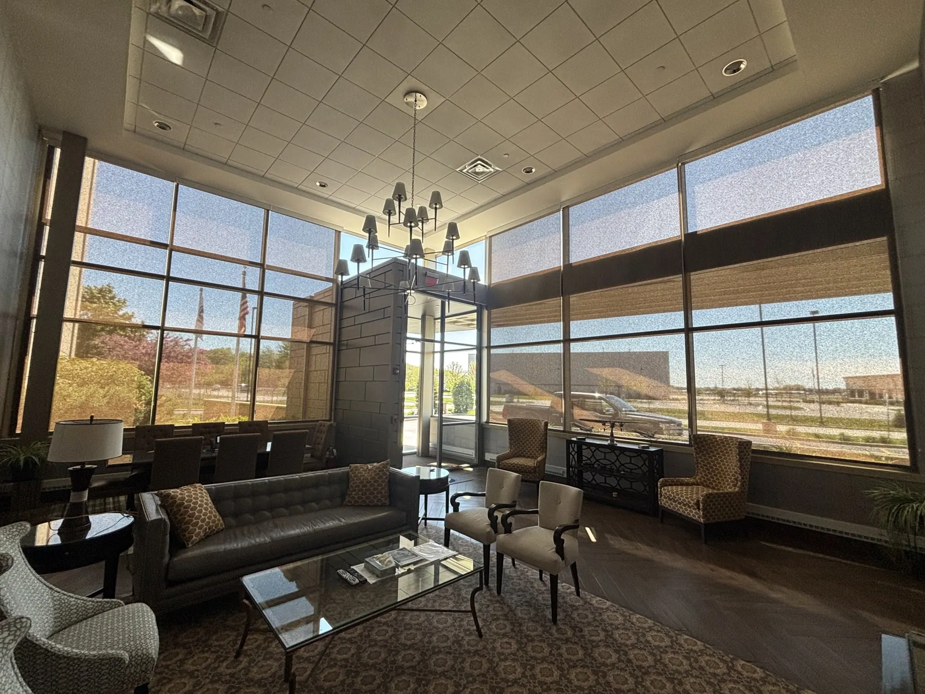 Solar shades on double-height windows in an office lobby